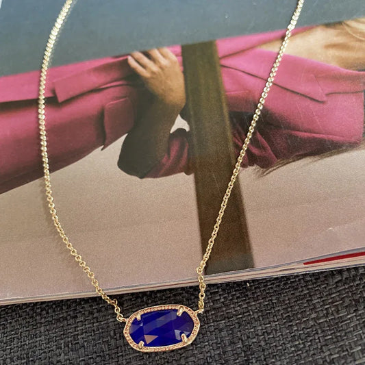 Preppy Kendra Scott necklace with oval blue gemstone pendant in a gold setting