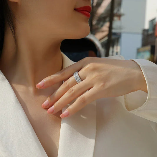 Full pavé moissanite ring on finger with white-sparkling stones, slim band