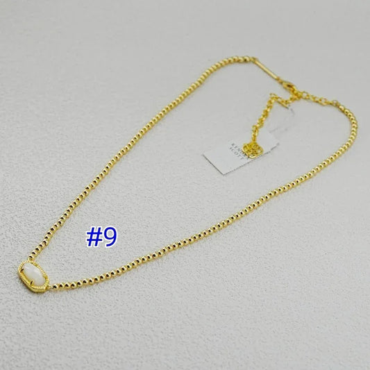 Gold-plated ball chain necklace with light teal oval gemstone bezel pendant.