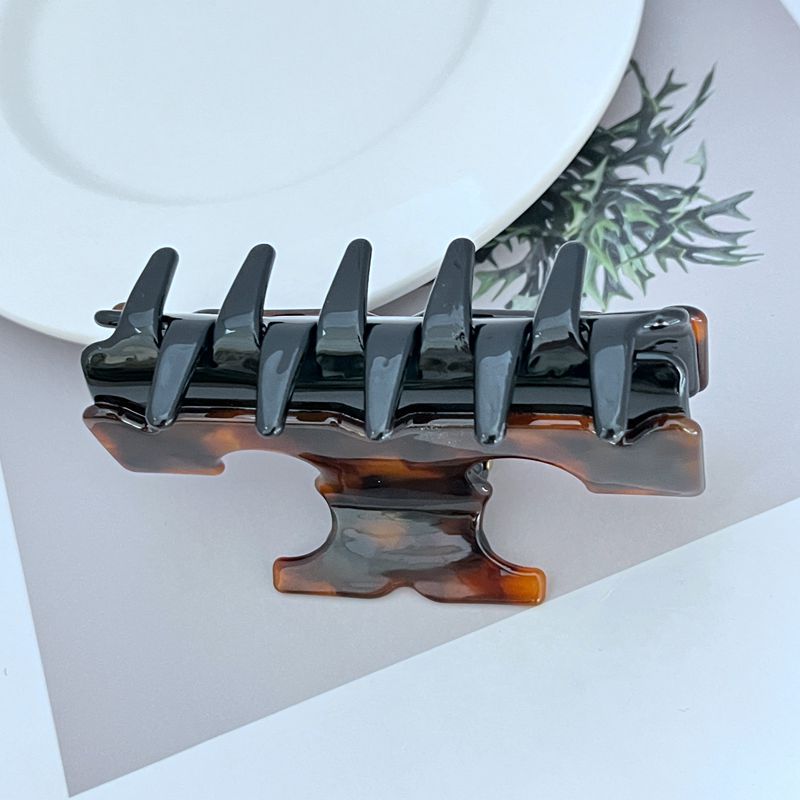 Two-tone T-shaped shark clip, dark finish with amber underside detail