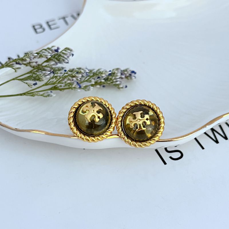 Round gold-tone logo stud earrings with scalloped bezel and cameo center detail