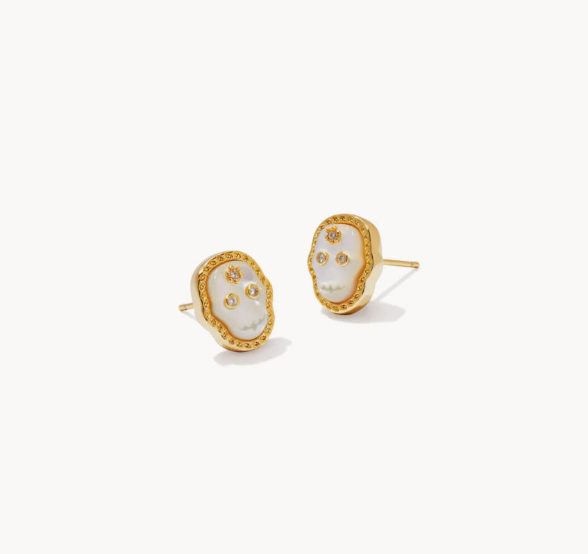 Gold stud earrings with white skull faces and small clear gem accents