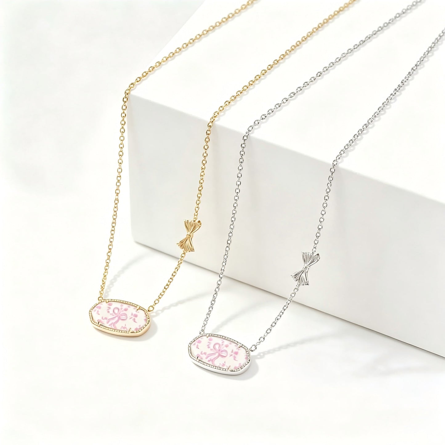 Gold-tone bow charm oval pendant necklace with pink floral enamel