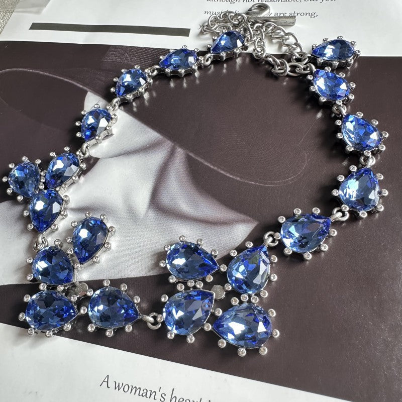 Silver-tone crystal necklace with vivid blue oval stones and linked chain
