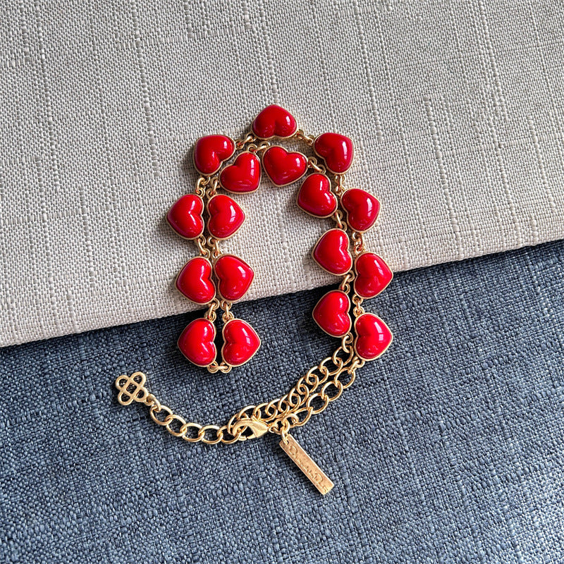 Red heart-shaped necklace with gold chain, lobster clasp, and heart charms