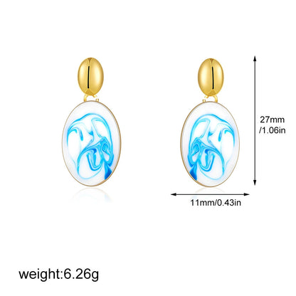 Gold-tone oval drop earrings with blue marble swirl inlay