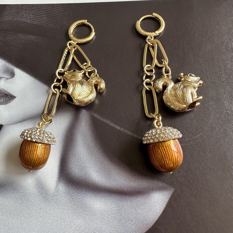 Gold-tone squirrel drop earrings with orange acorn beads and rhinestone caps