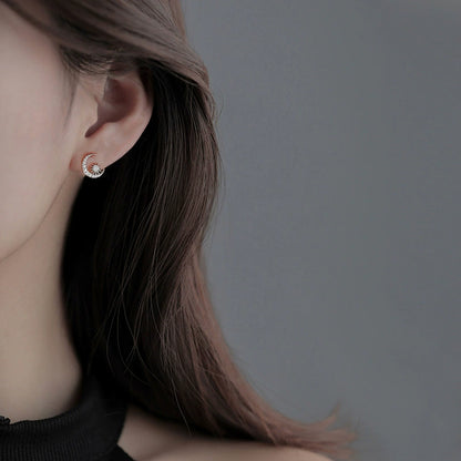 Moon and star diamond stud earrings in silver tone, worn on ear