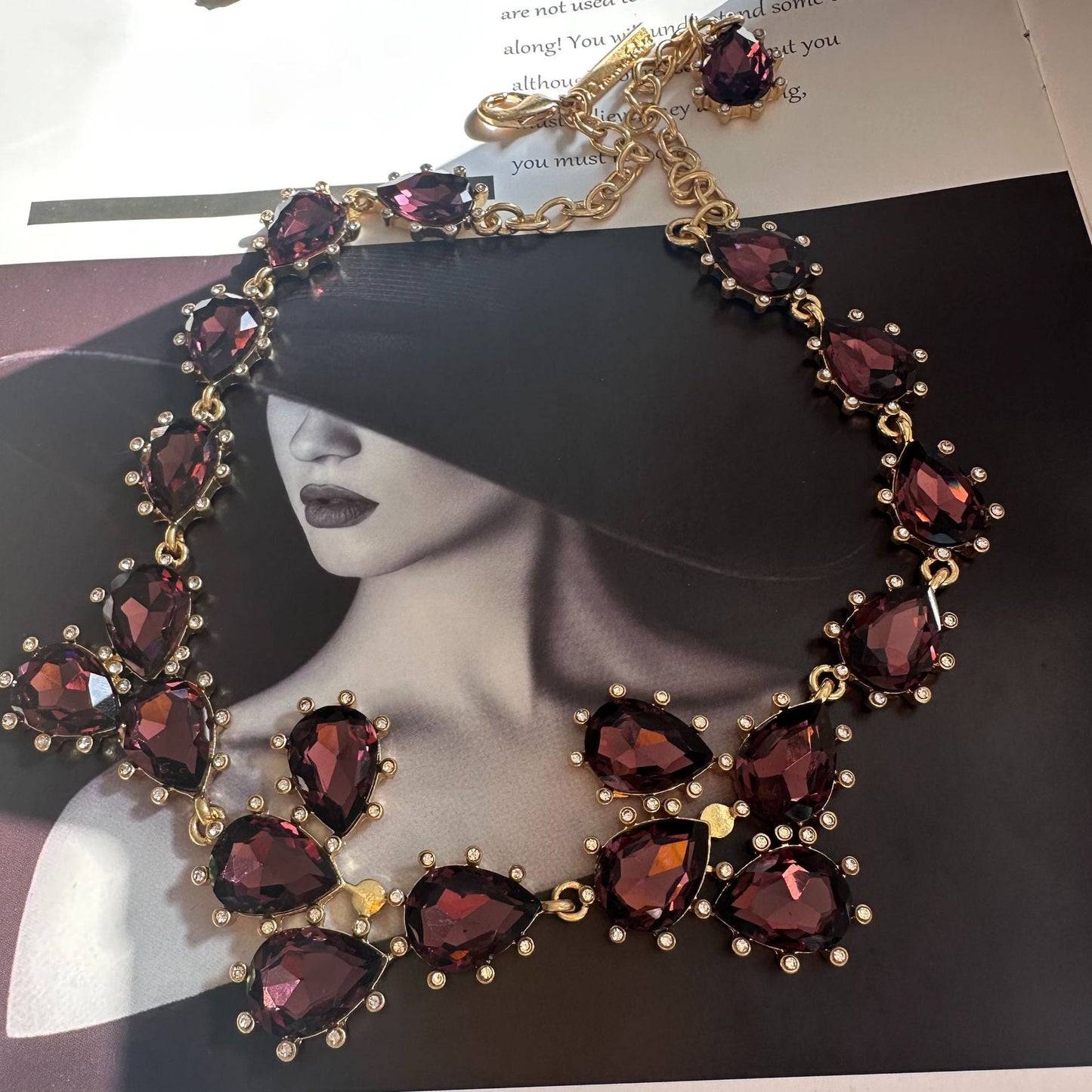 Gold-tone crystal necklace with deep purple oval stones and linked chain