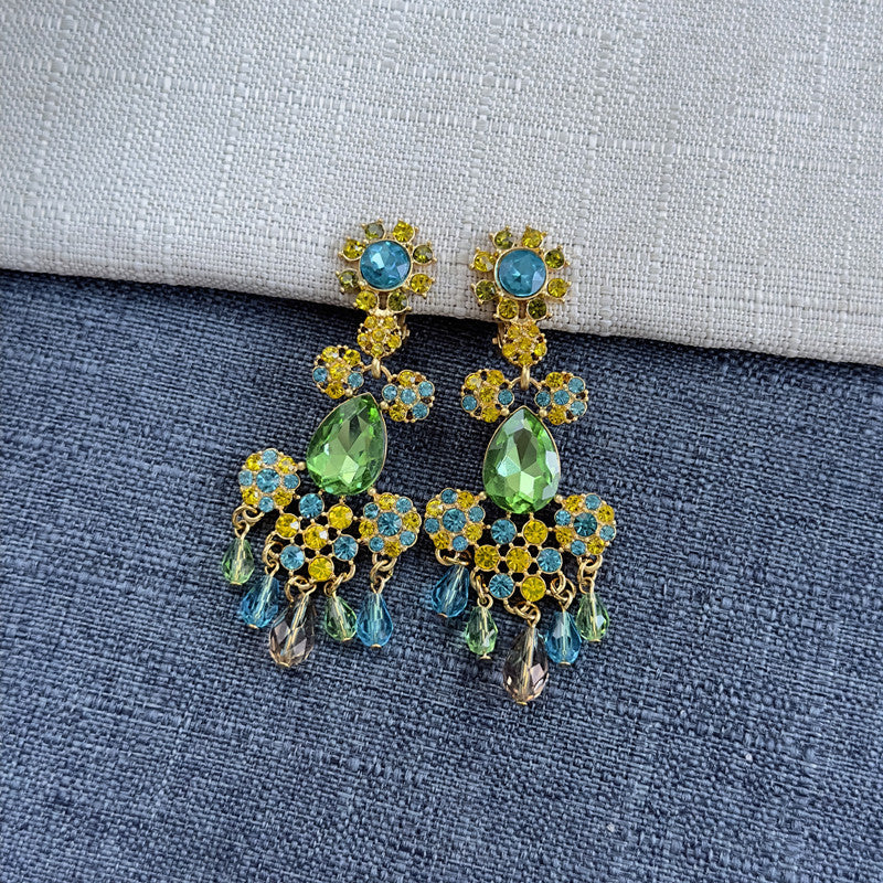 Long clip-on rhinestone tassel earrings with green, blue, and gold stones