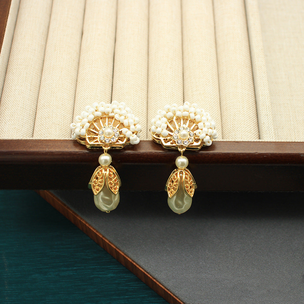 Pair of fan-shaped pearl earrings with gold crown centers and teardrop pearl drops