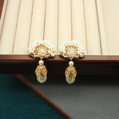 Pair of fan-shaped pearl earrings with gold crown centers and teardrop pearl drops