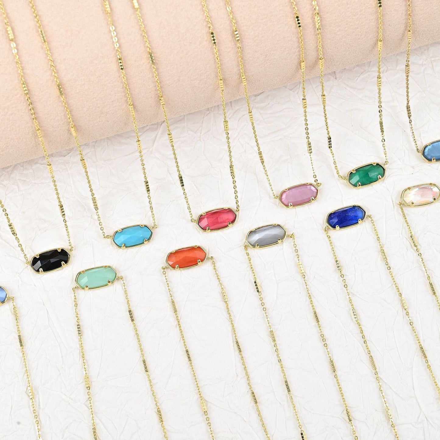 Assorted oval crystal pendant necklaces with gold chains in multiple colors
