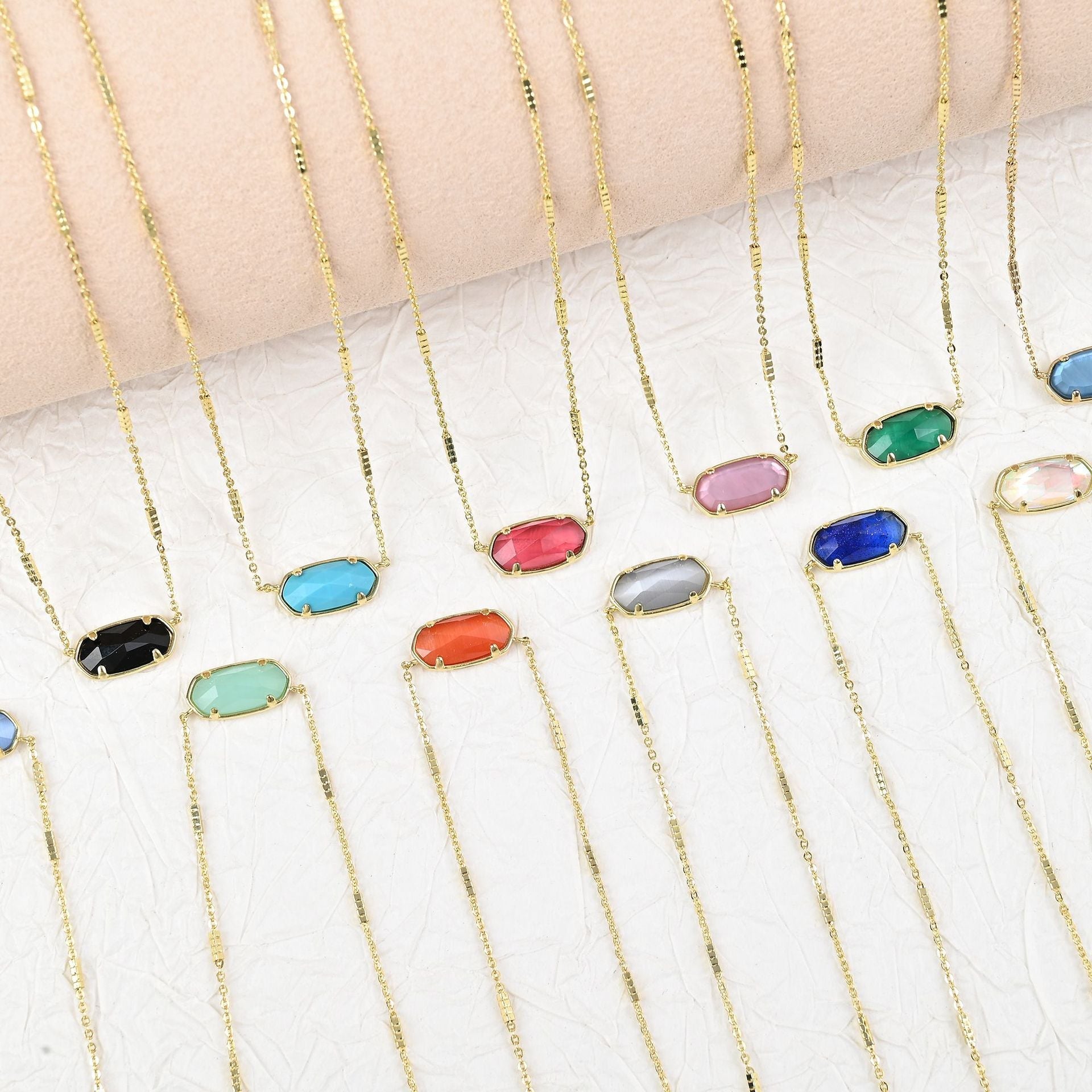 Assorted oval crystal pendant necklaces with gold chains in multiple colors