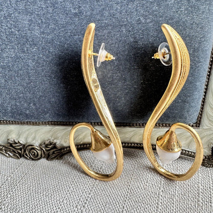 Gold clip-on earrings on posts, crescent hoops with small white flower drops