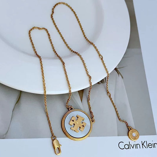 Gold-tone circle coin pendant necklace with light blue round charm and small clip detail