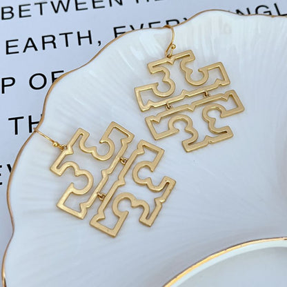 Gold openwork logo drop earrings with two stacked dangling geometric pieces, fishhook.