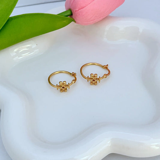 Gold-tone mini hoop earrings with small logo charm, hinged clasp detail