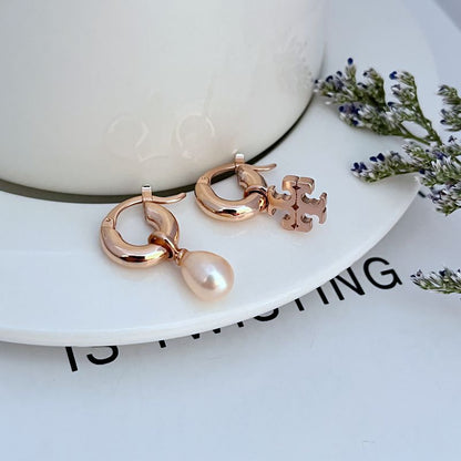 Rose gold asymmetrical pearl hoop earrings with dangling white pearl and charm detail
