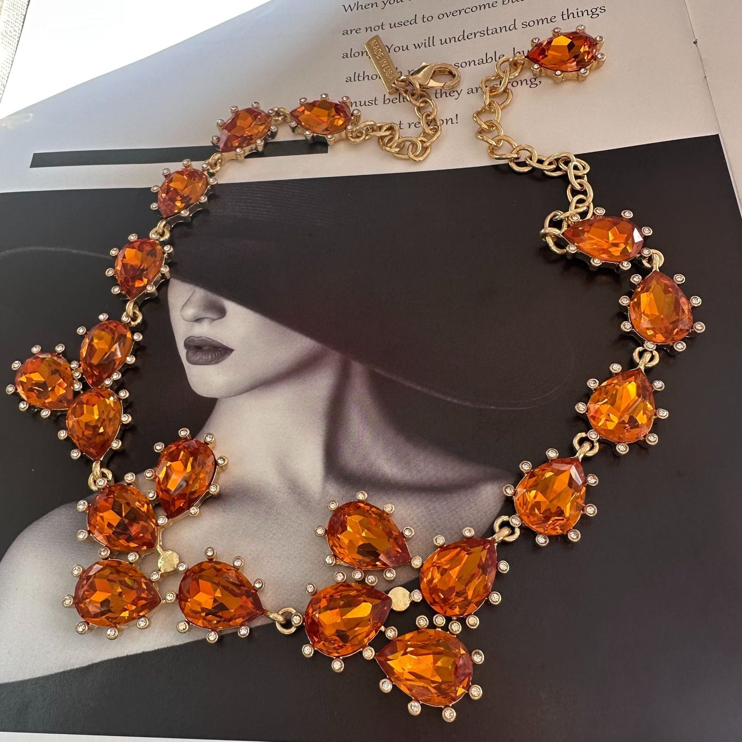 Gold-tone crystal necklace with orange oval stones and linked chain
