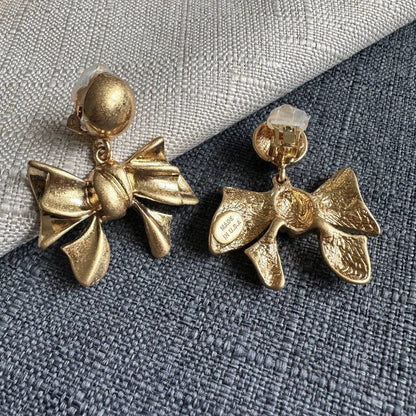 Gold-tone vintage metal bow earrings with clip backs, round ball tops, and stamped metal.