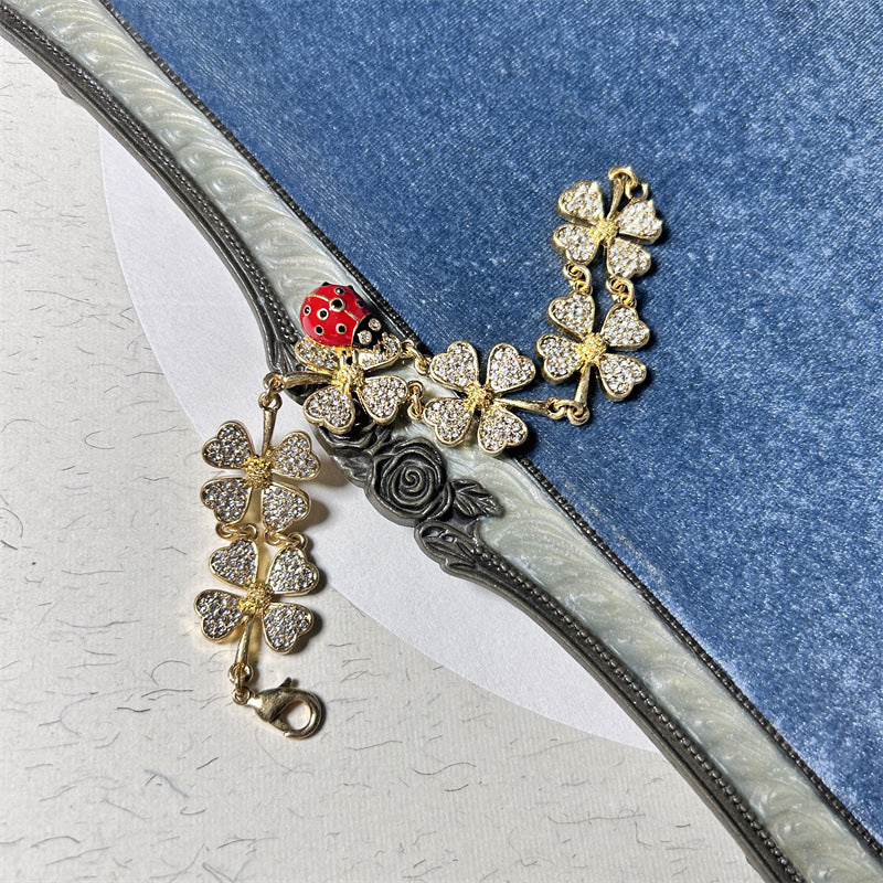 Ladybug and clover charm bracelet with gold-tone chain, silver glitter clovers, rose charm