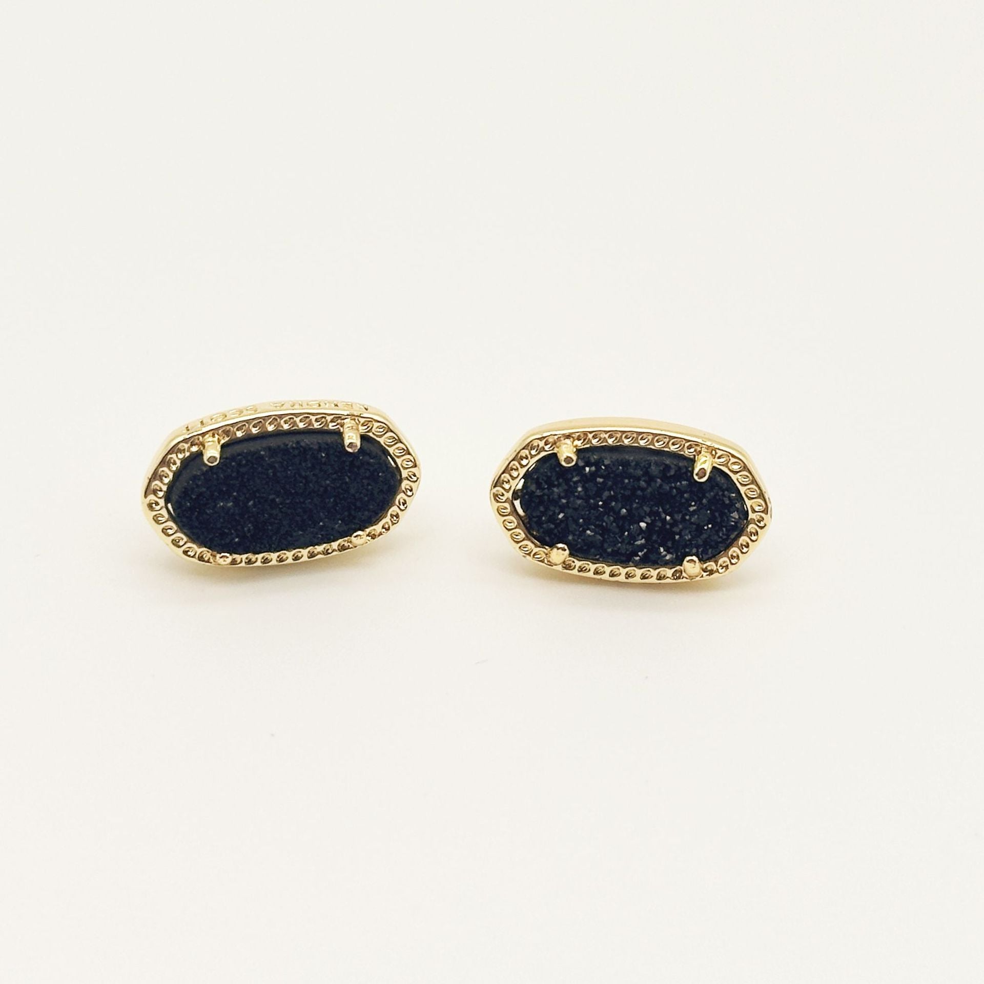 Kendra Scott oval gemstone stud earrings with dark blue crystal in gold bezel setting