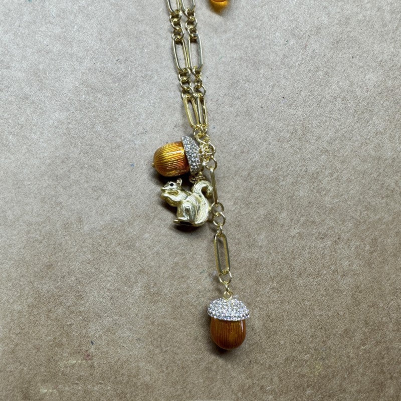Gold-tone pendant necklace with squirrel charm, orange bead accents, and rhinestone drop.