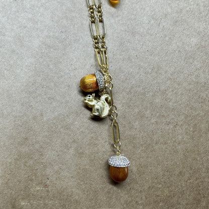 Gold-tone pendant necklace with squirrel charm, orange bead accents, and rhinestone drop.