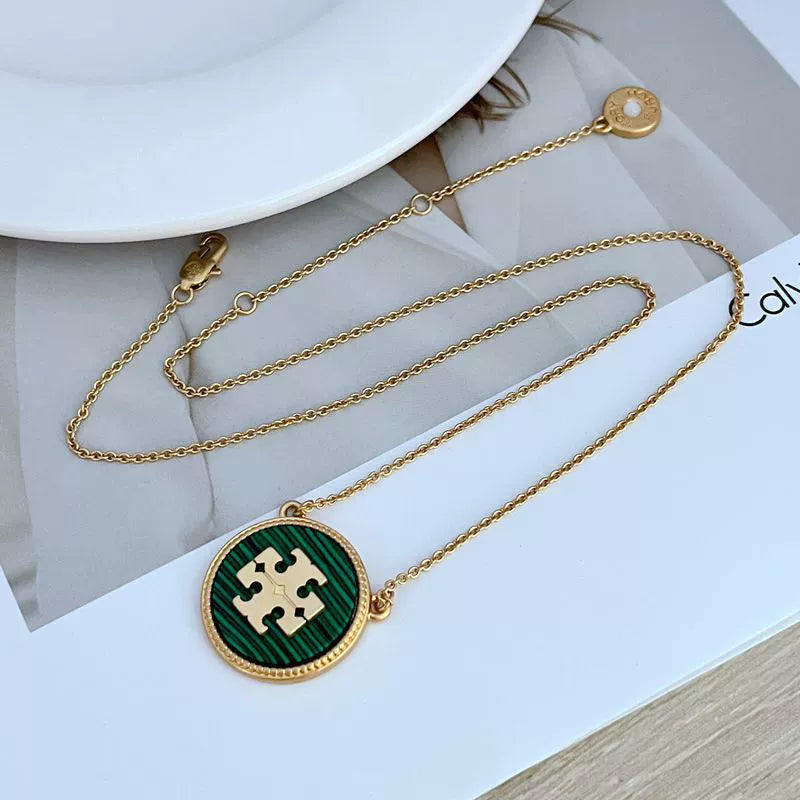 Gold-tone circle coin pendant necklace with green enamel round charm and chain links