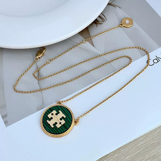 Gold-tone circle coin pendant necklace with green enamel round charm and chain links