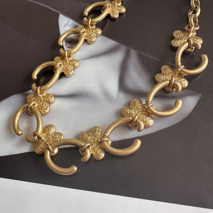 Gold-plated floral pendant necklace with gold clover charms and oval link chain