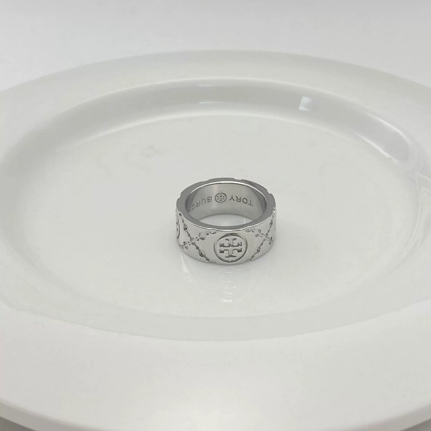 Silver-tone round logo metal ring with enamel pattern, engraved inner band