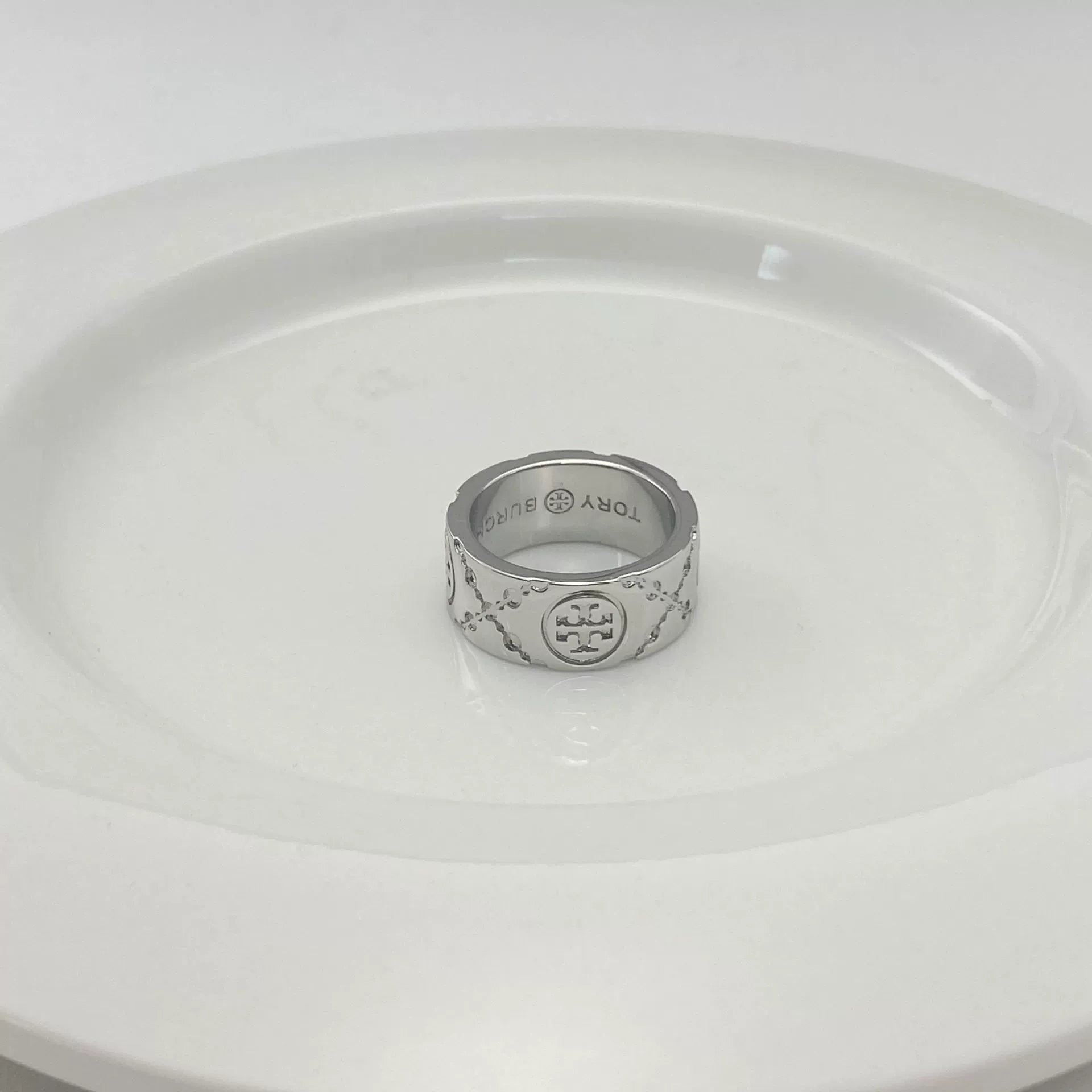 Silver-tone round logo metal ring with enamel pattern, engraved inner band