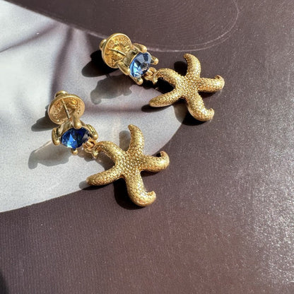 Vintage gold starfish stud earrings with dark blue round accents