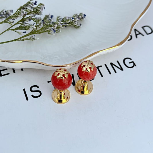 Red round pearl geometric stud earrings with gold-tone posts and backs
