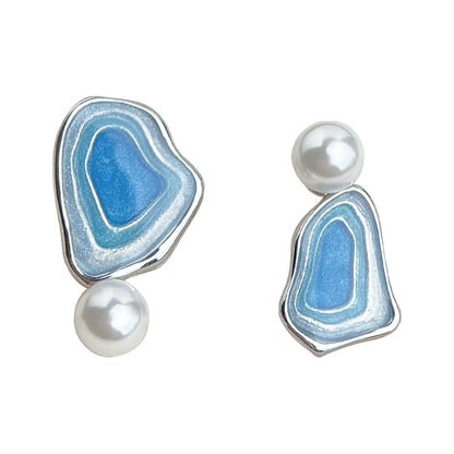 Close-up blue enamel triangle drop earrings with white pearl drops, silver-tone finish