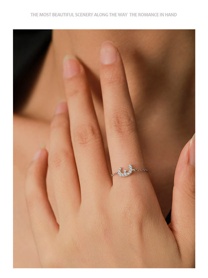 Silver-tone adjustable chain ring with small pavé charm on finger