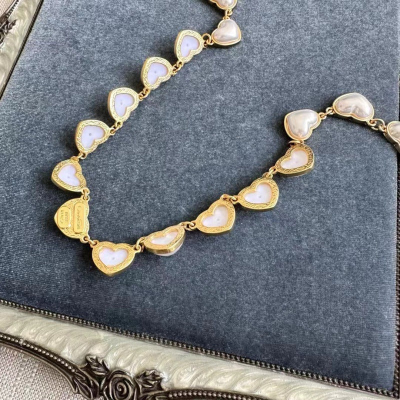 White heart-shaped necklace with gold chain and pearl-like 3D heart charms