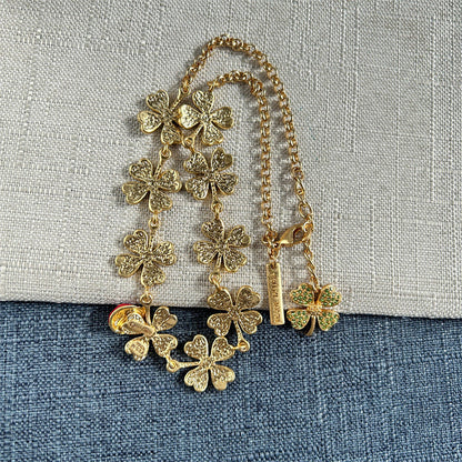 Gold-tone clover crystal necklace with ladybug bead charm, hanging chain view