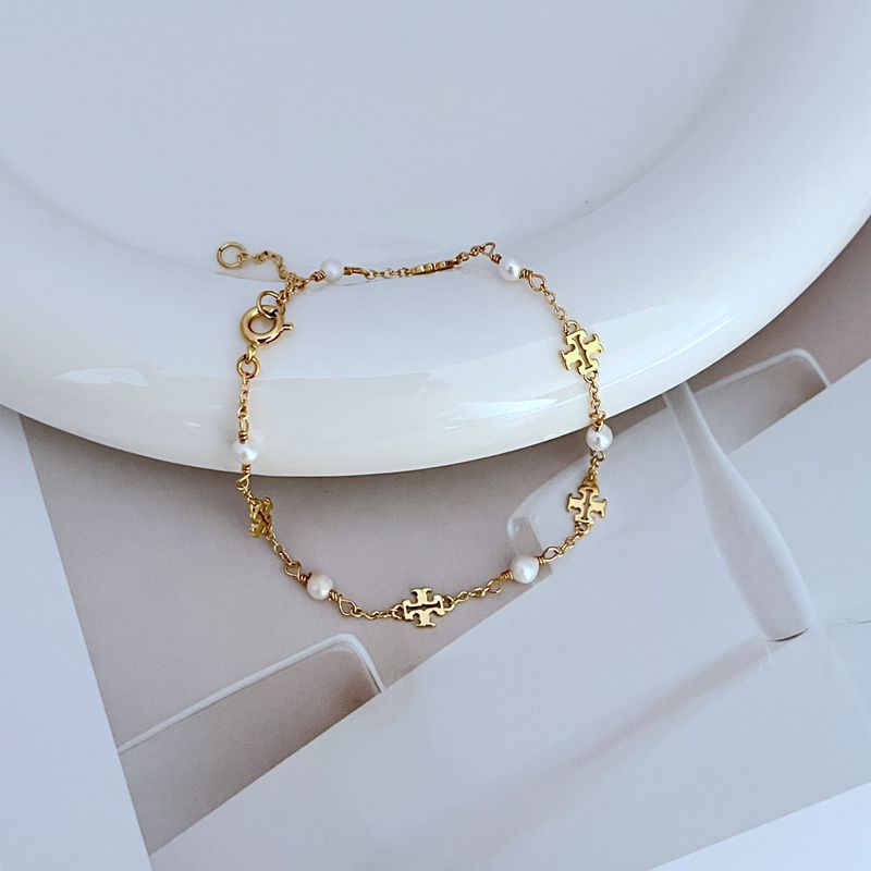 Gold-tone chain bracelet with freshwater pearls and logo charm stations