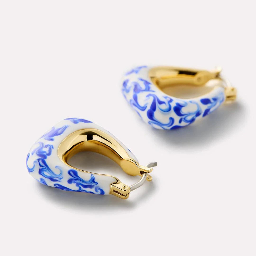 Close-up: gold-tone hoop earring with blue marble inlay and hinged clasp