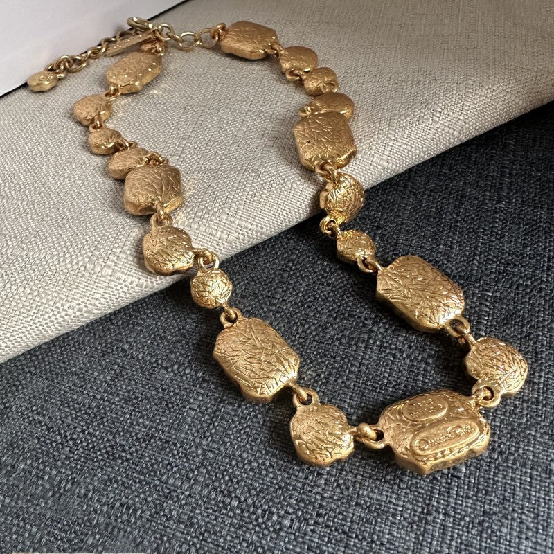 Gold-tone pendant necklace with textured oval links and clasp chain