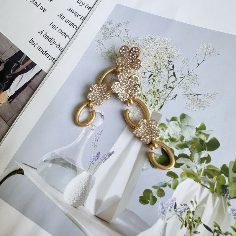 Floral dangle hoop earrings in gold tone with clear crystal flower clusters and loops