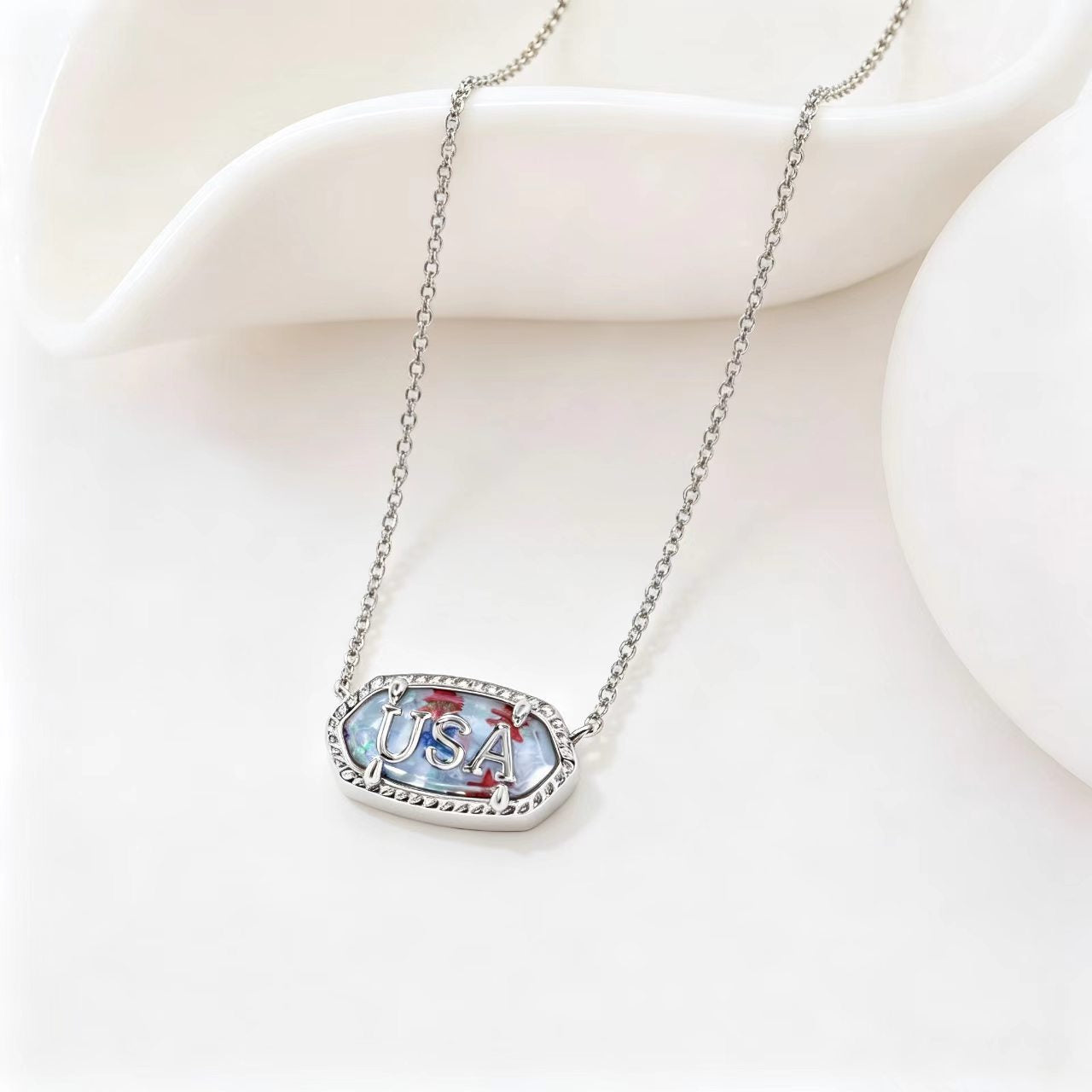 Silver-tone oval USA letter pendant necklace with blue enamel border