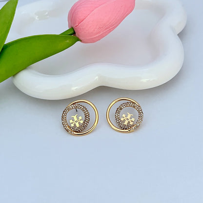 Gold-tone rhinestone halo stud earrings, circular logo center with polished gold rim