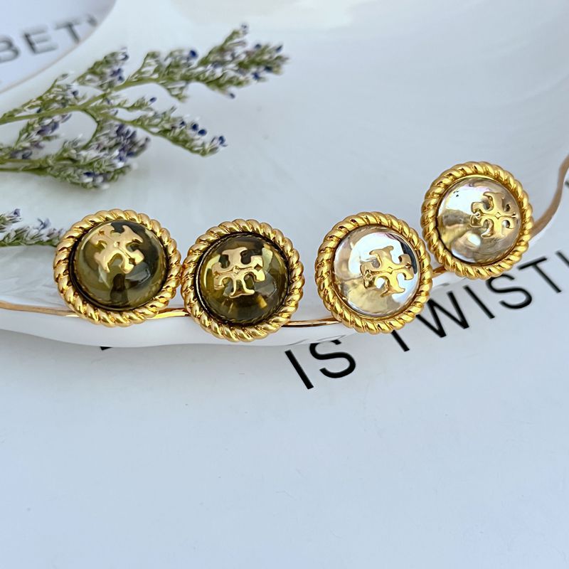 Set of round gold-tone stud earrings with logo medallion fronts, pair shown