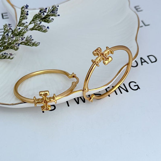 Gold-tone hoop earrings with raised Tory Burch logo centerpiece