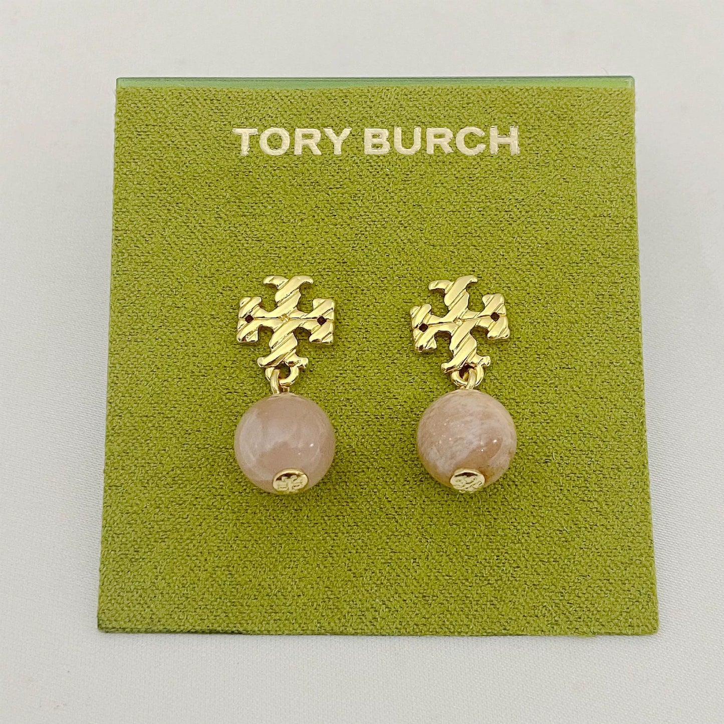 Gold-tone agate pendant earrings with round pale rose stones and leaf-like motif