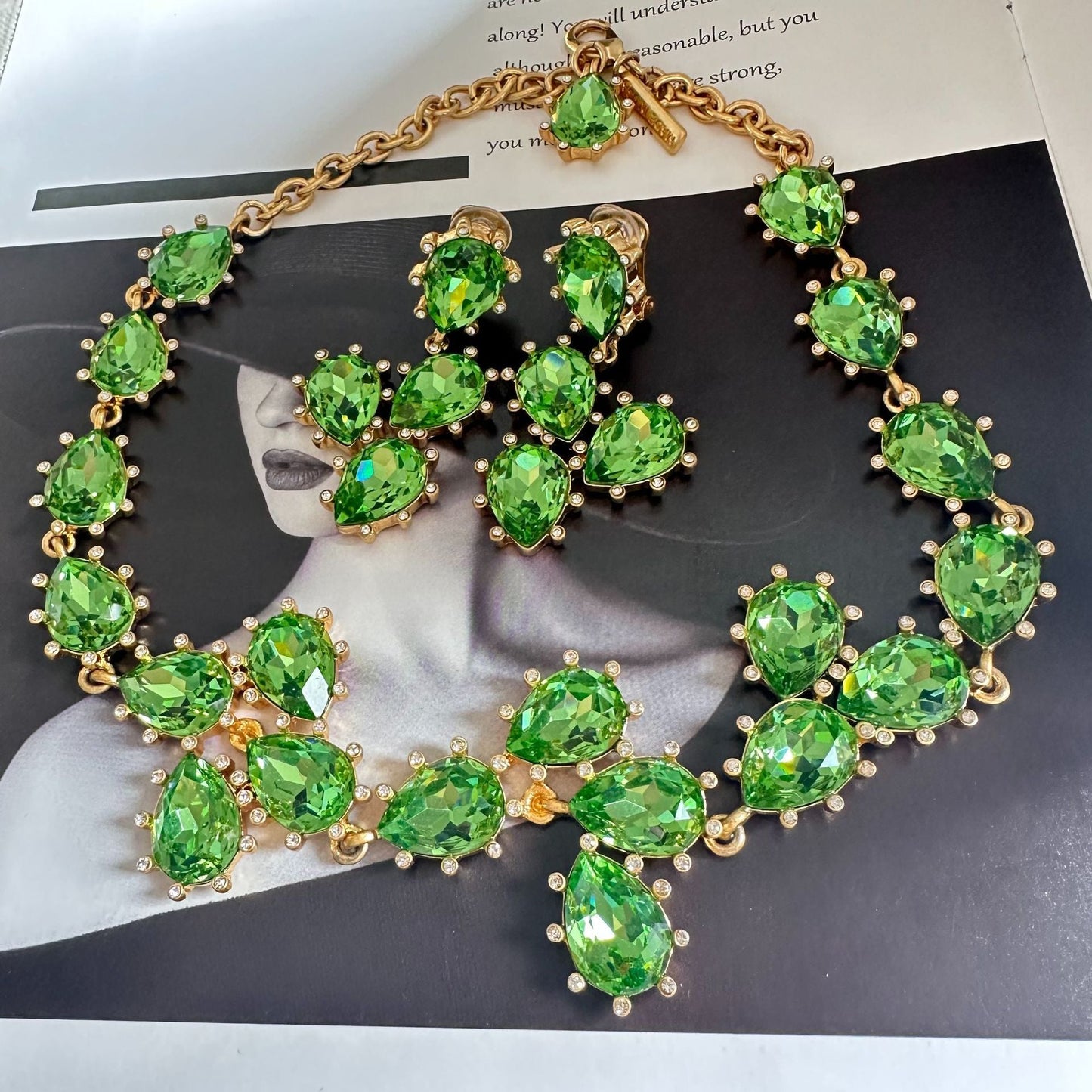Gold-tone crystal necklace with bright green oval stones and linked chain